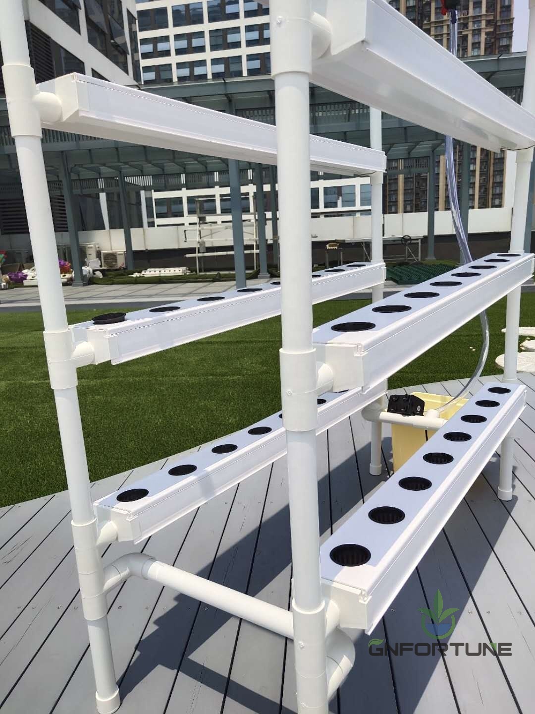 Closeup of white PVC NFT channels with pre-drilled planting holes on a home kit